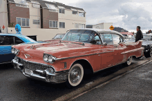 a red cadillac is parked on the side of the road with a license plate that says vmnyc