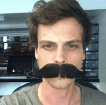 a man wearing a fake mustache is taking a selfie