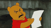 winnie the pooh is holding a piece of paper in his hand