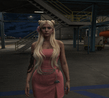 a woman in a pink dress stands in a parking lot