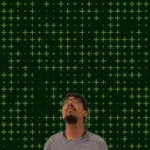a man stands in front of a green background with the number 21 in yellow