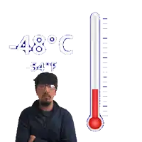 a man stands in front of a thermometer that reads 48 degrees c