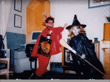 a man in a devil costume and a woman in a witch costume are posing for a photo