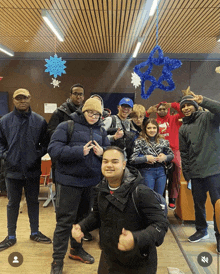 a group of young people are posing for a picture in front of a blue star