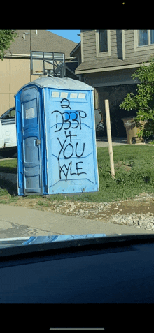 a blue portable toilet with graffiti on it that says db3p on it