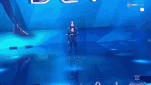 a woman is standing on a stage in front of a large screen while a man is standing behind her .