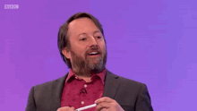 a man with a beard is on a purple background with the word contemplating on it