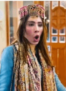 a woman wearing a turban and scarf is making a funny face .