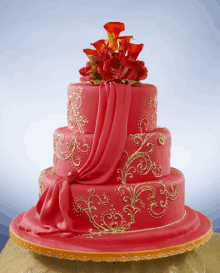 a red and gold cake with flowers on top