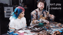 a man and a woman sit at a table with a sign that says " black lives matter " on it