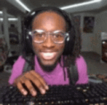 a man wearing headphones is typing on a computer keyboard .