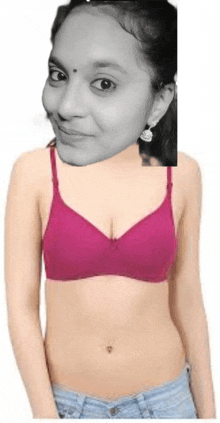 a woman is wearing a pink bra and shorts and has a picture of her face on her chest .