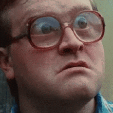 the man is wearing glasses and making a funny face .