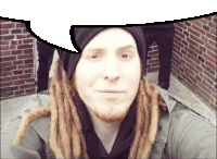 a man with dreadlocks takes a selfie with a speech bubble above him