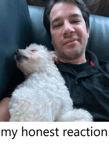 a man is laying on a couch with a small white dog sleeping on his lap