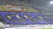 a crowd of people in a stadium with a banner that says " pour vous permetre de mieux manger tous les jours "