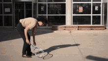 a man is holding a tennis racquet in front of a building that has a sign that says ' no parking ' on it