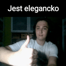 a man wearing headphones gives a thumbs up with the words jest elegancko above him