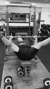 a black and white photo of a man lifting a barbell