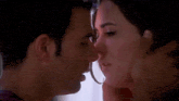 a man and a woman are kissing each other in a room .