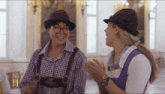 a man and a woman wearing hats are talking to each other