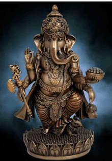 a statue of a elephant holding a bowl of fruit