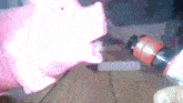 a pink piggy bank is sitting on a table next to a bottle