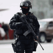 a police officer wearing a helmet and a mask is holding a gun .