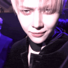 a close up of a person 's face with a black jacket on