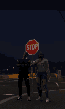 two people standing in front of a stop sign at night