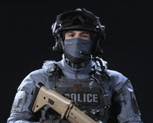 a police officer wearing a helmet and a mask is holding a gun .