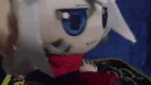 a stuffed animal with blue eyes and a scarf around its neck