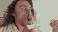 a man with long hair and a beard looks surprised