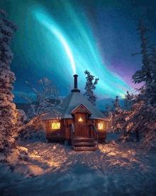 the aurora borealis shines brightly over a snowy cabin