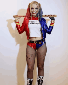 a woman in a harley quinn costume holds a bat over her shoulder