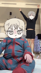 a baby in a blue and red outfit is sitting in front of a man in a black sweater