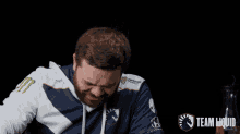 a man with a beard is wearing a blue and white team liquid jersey