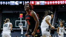 a woman wearing a jersey with the letter m on it is playing basketball