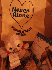 a stuffed animal is sitting next to a bag that says never alone