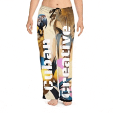 a woman is wearing a pair of pajama pants with a picture of a parrot and the word creative on the side