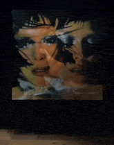 a woman walking in front of a painting of a woman