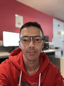 a man wearing glasses and a red hoodie that says ' ford ' on it