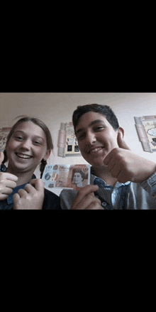 a boy and a girl are posing for a picture and the girl is holding a 10 pound bill