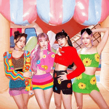 a group of girls are standing next to each other in front of an inflatable ice cream cone .