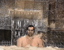 a man is standing in a bathtub with a waterfall in the background .