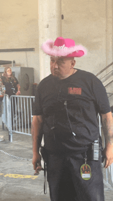 a man wearing a pink cowboy hat and a black shirt that says loud ranch