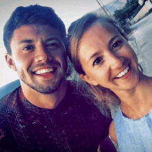 a man and woman are posing for a picture and smiling for the camera