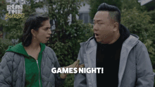 a man and a woman are standing next to each other and the man is saying games night