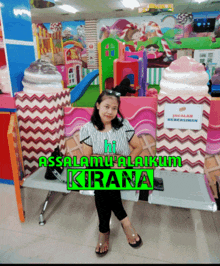 a little girl sits on a bench in front of a sign that says ' assalamualaikum kirana ' on it