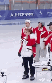 a group of people are standing on a ice rink in front of a sign that says a on it .